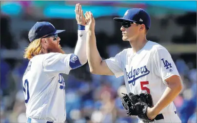  ?? ap pHoTo ?? Los Angeles Dodgers third baseman Justin Turner, left, celebrates with shortstop Corey Seager after the Dodgers defeated the San Diego Padres 6-4 in a baseball game in Los Angeles on Sunday.