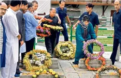  ?? — PTI ?? PDP chief Mehbooba Mufti offers floral tribute to the martyrs of 1931, who were killed by the Dogra police, at Ziyarat Naqshband Sahab in Srinagar.