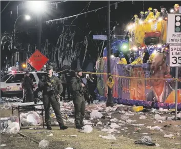  ?? YUNE/THE NEW ORLEANS ADVOCATE VIA AP DAVID GRUNFELD/THE TIMES-PICA- ?? Police work the scene of a shooting at the Krewe of Bacchus parade on Sunday. Five people were shot, including a young girl, during a Mardi Gras parade in New Orleans, police said, and a suspect was in custody.