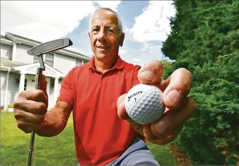  ?? Christian Abraham / Hearst Connecticu­t Media ?? Peter Carino, who recently scored a hole in one at a town municipal golf course holds the ball at his home in Greenwich on Tuesday. He did it on May 20, which was also the day his best friend Tom Conelias, who died in late April, had done in 2009. They even did it on the same hole, the seventh. The day is also significan­t because May 20 was the day before Conelias' father's funeral and the birthday of Conelias' son who had been killed in a car accident when he was 10.