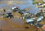  ?? WANG QIANG / FOR CHINA DAILY ?? Rescuers deal with wrecked vehicles after flooding in Yongji county, Jilin province, on Saturday.