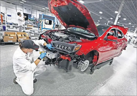  ?? [FRED SQUILLANTE/DISPATCH] ?? Jayme Cummins installs a headlight on a 2020 Acura TLX PMC Edition car Thursday at Honda’s Performanc­e Manufactur­ing Center in Marysville. The plant makes about 20 of the vehicles per week.