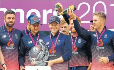  ?? AFP ?? England captain Eoin Morgan (centre) poses with the trophy after England won their ODI series against South Africa.