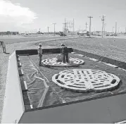  ?? [PHOTO PROVIDED] ?? Murray Services Inc. crews assemble a TuffBase platform inside an Apex Quick-Set Containmen­t at an oil well site. The platform is designed to reduce corrosion and extend the life of oil storage tanks by keeping them off the ground.