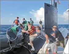  ?? JENNIFER MCDERMOTT/THE DAY ?? Civilian system engineers climb aboard the USS Missouri (SSN 780) at sea near the Bahamas March 9.