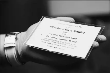  ?? WADE VANDERVORT ?? Kelli Luchs, archivist for the Las Vegas Convention and Visitors Authority, shows a 1963 invitation to a speech by President John F. Kennedy at the Las Vegas Convention Center. The ticket is part of the LVCVA’S extensive collection of photos, which Luchs is in charge of digitizing.