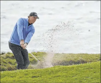  ?? Eric Risberg The Associated Press ?? Phil Mickelson chips out of a bunker toward the seventh green Saturday in the third round of the AT&T Pebble Beach National Pro-Am at Pebble Beach Golf Links.