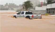  ?? Reuters ?? A motorist in an SUV tries to push on through a flooded street in Muscat yesterday.