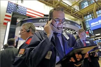  ?? Richard Drew/Associated Press ?? Trader Gregory Rowe, center, works on the floor of the New York Stock Exchange on Tuesday. U.S. stocks rose in early trading as investors shifted money into technology companies after a broad sell-off Monday over fears that the spread of a deadly virus in China could affect the global economy.