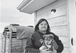  ?? ARIELLE ZIONTS KFF Health News/TNS ?? Katherine Goodlow holds Coco the puppy outside her grandmothe­r’s home in Hisle on the Pine Ridge Reservatio­n in South Dakota.