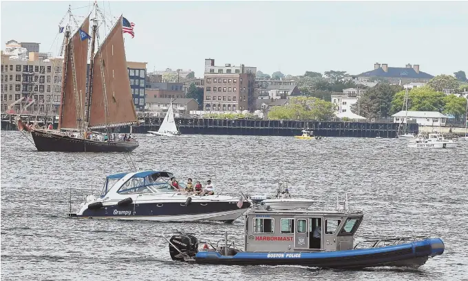  ??  ?? A FINE DAY: Old and new vessels share the water during Sail Boston yesterday. Below, sunny weather brings visitors out to view the tall ships. At right, George Shea declares Geoffrey Esper of Oxford the hot dog eating champ, after downing 51 hot dogs...