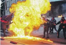  ?? AFP ?? Albanian policemen attempt to avoid a petrol bomb thrown during protests in Tirana