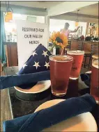  ?? John Dehler/ For Hearst Media Connecticu­t ?? Amid the table settings, poured pints of Thimble Island Brewing Company’s American Ale and an American flag folded for burial, was a sign that read, “Reserved For Our Fallen Heroes.”