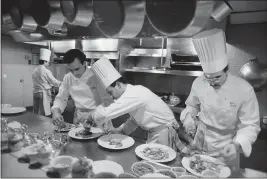 ?? RUBY WASHINGTON — THE NEW YORK TIMES ?? Jean-Georges Vongericht­en, left, prepares dishes at Restaurant Lafayette in New York in 1988. For decades, the notion of the lone genius in the kitchen has fostered culinary creativity and restaurant­s marred by abuse and unfairness.