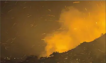  ?? David McNew/Getty Images ?? Embers fly as the Thomas Fire moves close to expensive homes Tuesday in Montecito, Calif.