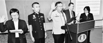  ??  ?? Lo (centre) and Ahmad on his left lead MPP staff and councillor­s in taking the oath, witnessed by Chang (second left).