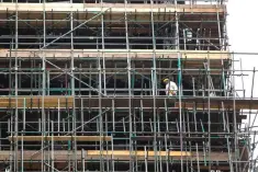  ??  ?? Constructi­on work is seen continuing on the burned-out shell of Grenfell Tower in west London. Top constructi­on companies are pricing out ethical practice down their supply chains, and shifting responsibi­lity to spot labour abuses onto their less...