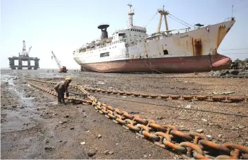  ??  ?? Workers pull a rope tied to a decommissi­oned oil rig to dismantle it at the Alang shipyard in the western state of Gujarat, India.The shipping industry will this year scrap the largest number of oil tankers in over half-a-decade, driven by weak...
