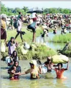  ?? MUNIR UZ ZAMAN/AFP ?? Rohingya refugees walk through a shallow canal after crossing the Naf River as they flee violence in Myanmar to reach Bangladesh in Palongkhal­i near Ukhia yesterday.