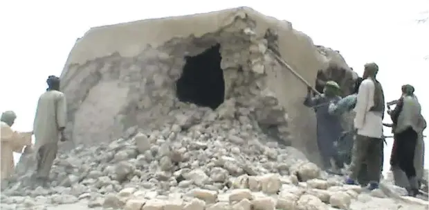  ?? AFP / GETTY IMAGES ?? This image taken in July 2012 shows Islamist extremists destroying a holy site in Timbuktu, Mali. Ahmad al-Faqi al-Mahdi pleaded guilty Monday at the Internatio­nal Criminal Court to smashing shrines and damaging a mosque in the ancient city.