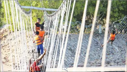  ?? PHA LINA ?? At the obstacle course, wooden sheets and car tyres hang above the water, connected by nets in three places.