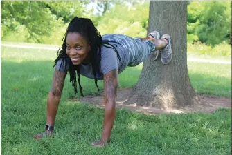  ??  ?? Laura Washington does a plank exercise using a tree at Manatawny Park in Pottstown.