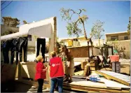  ?? AP PHOTO BY RAMON ESPINOSA ?? Efrain Diaz Figueroa talks to volunteers from "Caritas" at the remains of the house of his sister destroyed by Hurricane Maria in San Juan, Puerto Rico, Monday.