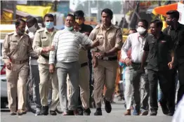  ?? — PTI ?? Gangster Vikas Dubey in the custody of the Madhya Pradesh police after he was arrested at a temple in Ujjain on Thursday.