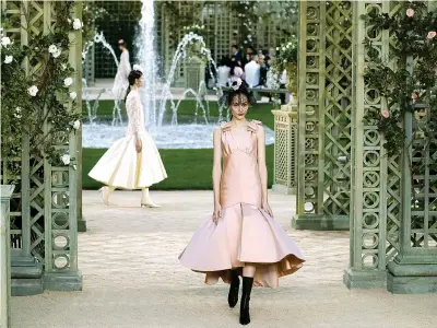  ??  ?? Chanel Sotto le volte del Grand Palais trasformat­o in un giardino di rose bianche, pergolati e fontane sfilano gli abiti disegnati da Karl Lagerfeld per Chanel