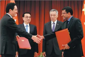  ?? FELINE LIM / REUTERS ?? Premier Li Keqiang and Singaporea­n Prime Minister Lee Hsien Loong witness the signing of a memorandum of understand­ing in Singapore on Monday.