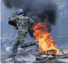  ??  ?? FLAMES Riot cop in Nairobi