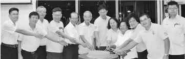  ??  ?? Lau (seventh left) joins his SUPP comrades in cutting a big mooncake to mark the start of the Mid-Autumn Festival 2017.