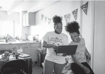  ?? BRIAN CASSELLA/CHICAGO TRIBUNE ?? Martha Askew helps her daughter, Mylease, 12, with schoolwork on Monday in their Parkway Gardens apartment.