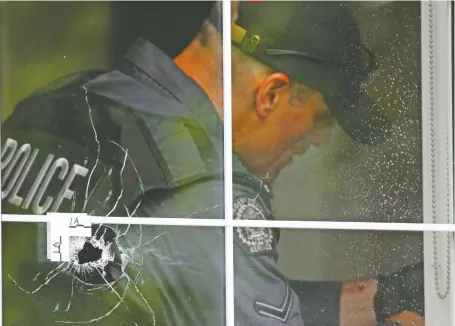  ?? GAVIN YOUNG ?? Police remove a bullet from a wall after a shooting incident in June. Chief Mark Neufeld vows city police will make a dent in gun crime this year.