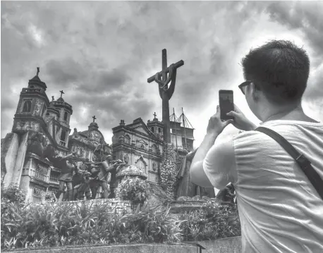  ??  ?? A tourist takes a photo of the Heritage of Cebu Monumental Sculptural Tableau in Barangay Parian, Cebu City. (SunStar file)