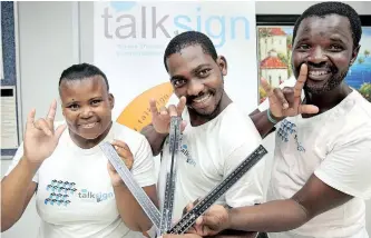  ?? News Agency (ANA) | SHELLEY KJONSTAD African ?? AT THE official launch of the KZN Blind and Deaf Society TalkSign campaign this week, from left, Sibongile Shandu, Zaba Ngcobo and Mbongeni Mbhanjwa show branded rulers to help spread the word. The society offers a basic sign language class and has started encouragin­g the use of the language by all at schools, companies, hospitals and government department­s.