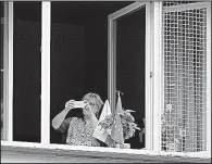  ?? AP/CZAREK SOKOLOWSKI ?? A Polish woman displays a European Union flag in her window during an EU street protest in Warsaw.