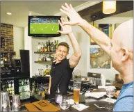  ?? Hearst Connecticu­t Media file photo ?? Bartender Keith Maloney high-fives patron Ryan Buzzell, of Danbury, during the action of the World Cup championsh­ip soccer match between Germany and Argentina in 2014 at Mezon Tapas Bar &amp; Restaurant in Danbury.