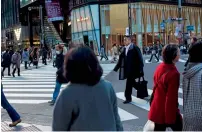  ?? — AFP ?? People cross an intersecti­on in the Ginza shopping district in Tokyo. Consumer demand has remained tepid in 2016.