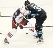  ??  ?? Sharks' Logan Couture, right, battles for the puck with Markus Nutivaara in the second period.