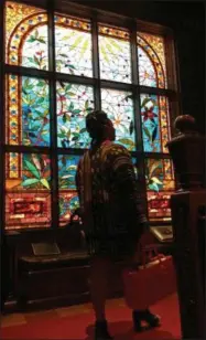  ??  ?? This June 16, 2017photo shows Lauren Craig walking in front of a stained glass window in the Ballantine House, a historic 1885mansio­n that is a wing of the Newark Museum in Newark, N.J. The house was owned by the family that built the Ballantine Beer...