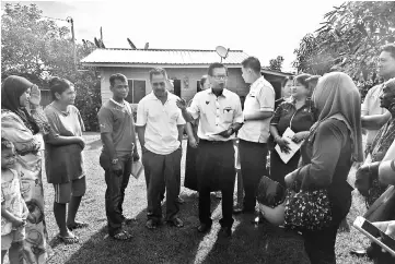  ??  ?? Lee (fifth left) briefs the residents affected by the transforme­r theft.