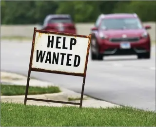  ?? NAM Y. HUH — THE ASSOCIATED PRESS FILE ?? A help-wanted sign is displayed at a gas station in Mount Prospect, Ill., in July. The gulf between record job openings and a lack of people taking those jobs is forcing Wall Street to reassess the pace of the economic recovery.