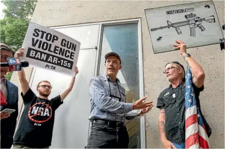  ?? PHOTO: AP ?? National Rifle Associatio­n member and Donald Trump supporter Jim Whelan, centre, argues with protesters outside the NRA’s annual convention in Dallas.