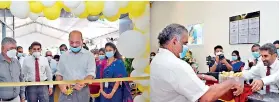  ??  ?? Chairman Kanchana Ratwatte cutting the ribbon, officially opening the new branch. The General Manager Gunasekera is also in the picture