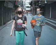  ?? TOM VAN CAKENBERGH­E/THE NEW YORK TIMES ?? Ana Pautler, left, and Mike Dobie return to their hotel through deserted streets Thursday in Kathmandu, Nepal.