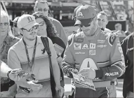  ?? Terry Renna / AP ?? Dale Earnhardt Jr. (right) signs autographs in the garage area during practice for today’s NASCAR Cup Series auto race at Homestead-Miami Speedway in Homestead, Fla.