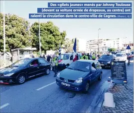  ??  ?? Des «gilets jaunes» menés par Johnny Toulouse (devant sa voiture ornée de drapeaux, au centre) ont ralenti la circulatio­n dans le centre-ville de Cagnes. (Photo L. Q.)