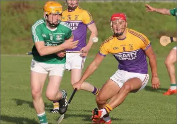  ??  ?? Naomh Eanna’s Aodhan Doyle goes up against Lee Chin of Faythe Harriers.