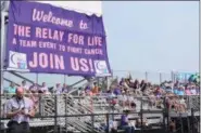  ?? MARIAN DENNIS — MEDIANEWS GROUP ?? Supporters sit on the bleachers at Pottsgrove High School beneath a giant purple sign on display for the Relay for Life.